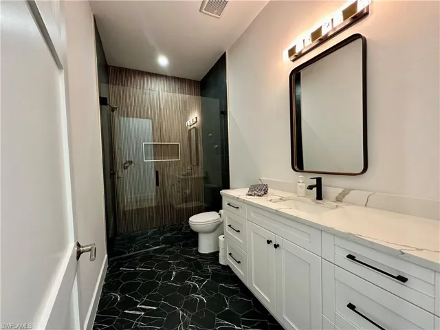 Full bath with vanity and a shower stall
