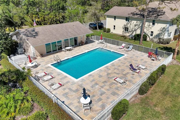 Pool featuring a patio area, a lawn, and fence