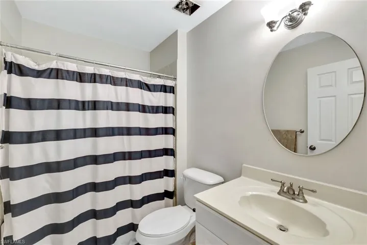 Bathroom featuring toilet, a shower with shower curtain, and vanity