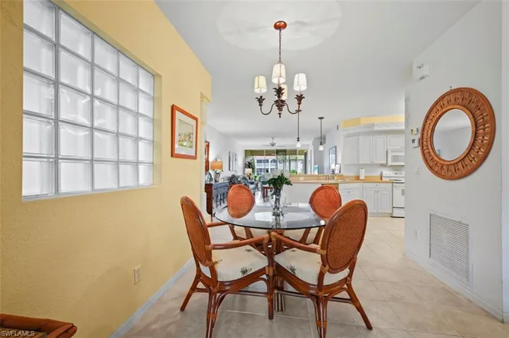 Tiled dining area featuring an inviting chandelier and sink