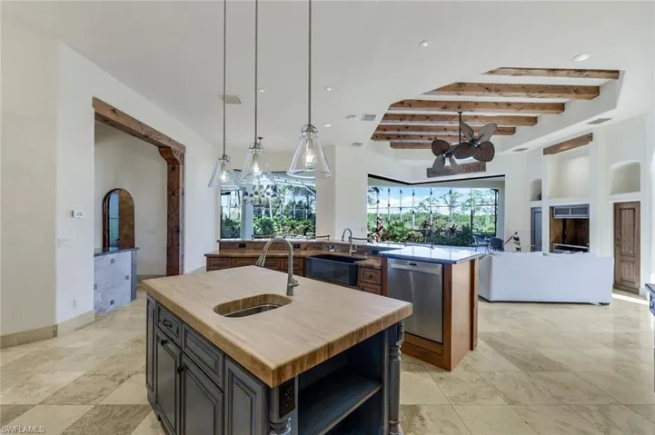 Kitchen with a center island with sink, beam ceiling, stainless steel dishwasher, and sink