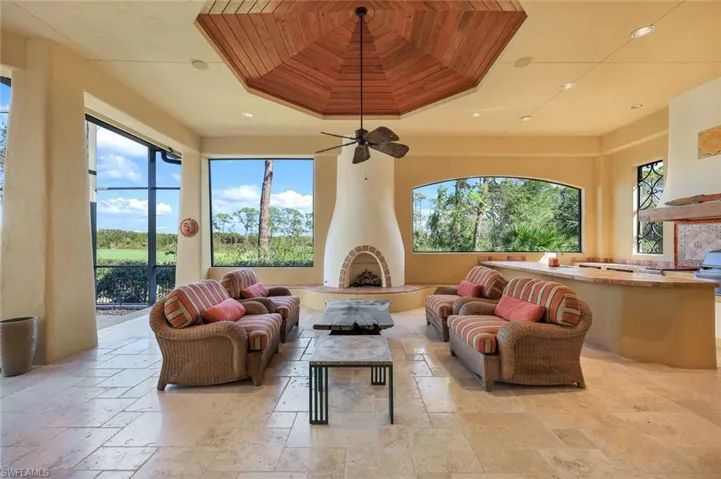 Living room featuring plenty of natural light, ceiling fan, wooden ceiling, and a tray ceiling