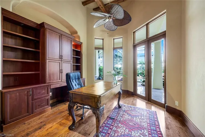 Office space featuring beam ceiling, ceiling fan, light hardwood / wood-style flooring, and french doors