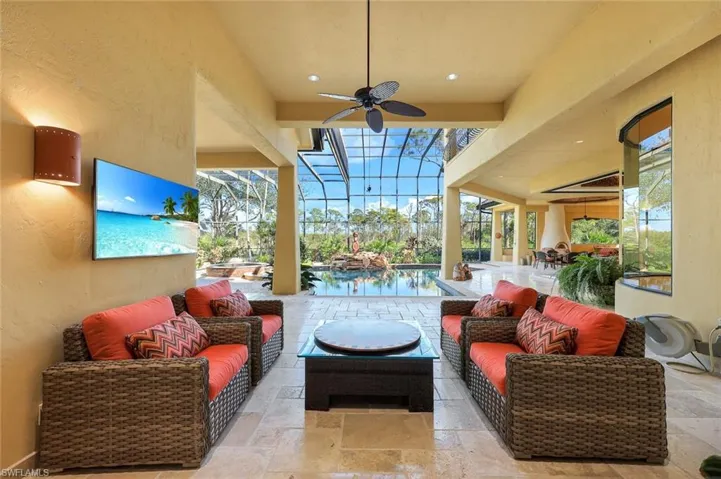 View of patio / terrace with outdoor lounge area, ceiling fan, a lanai, a swimming pool, and a water view
