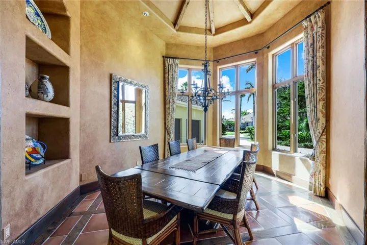 Tiled dining area with a high ceiling and a chandelier