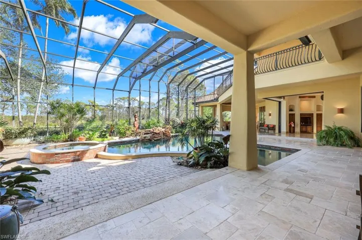 View of pool featuring an in ground hot tub, glass enclosure, and a patio area