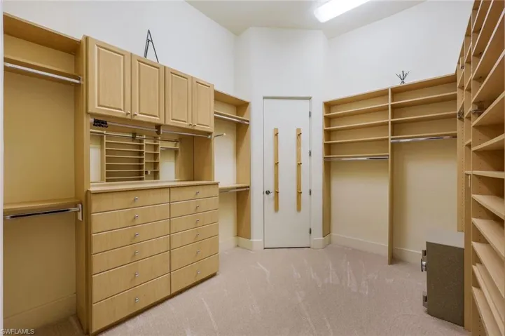 Spacious closet with light colored carpet