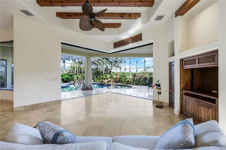 Living room featuring ceiling fan and beam ceiling