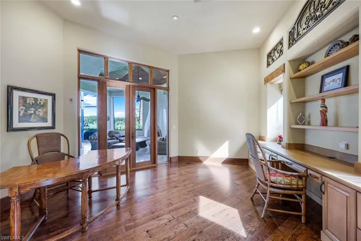 Office with hardwood / wood-style floors, built in desk, and french doors