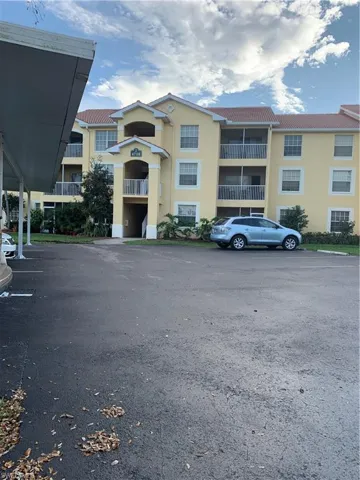 View of apartment building / complex featuring uncovered parking