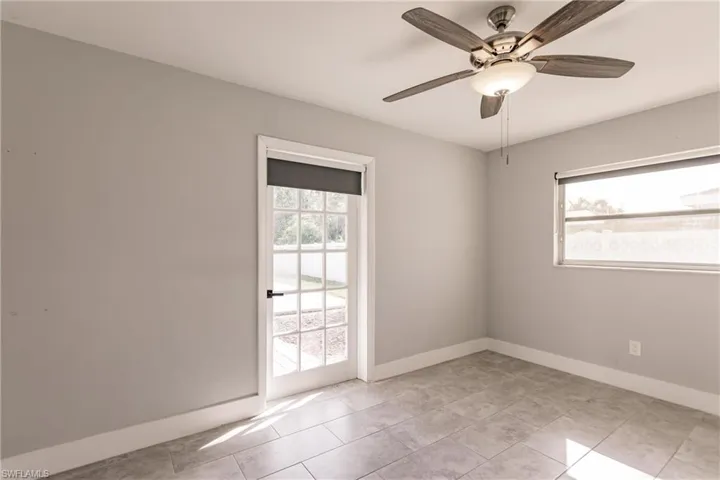 Spare room featuring plenty of natural light, ceiling fan, and light tile patterned floors