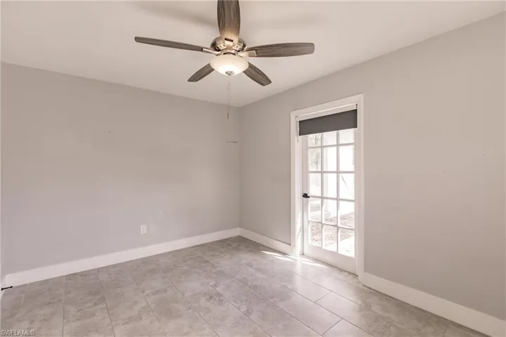 Unfurnished room featuring a ceiling fan and baseboards