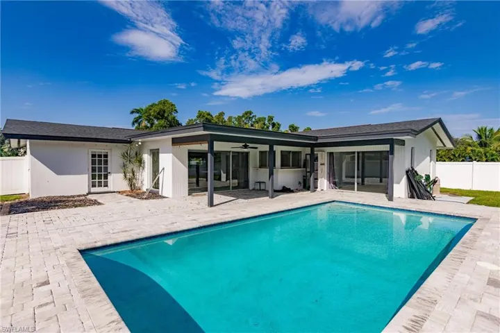 Back of house with a ceiling fan, a patio, and a shingled roof