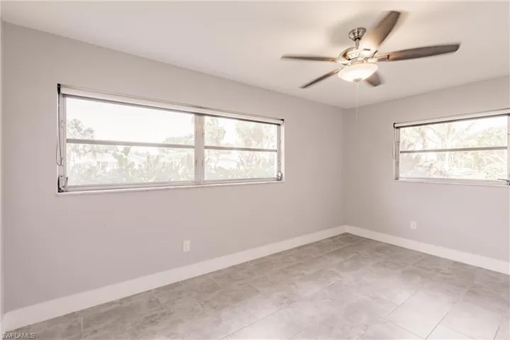 Empty room featuring baseboards and a ceiling fan