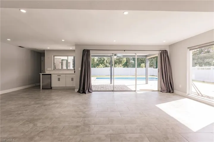 Unfurnished living room featuring baseboards and recessed lighting