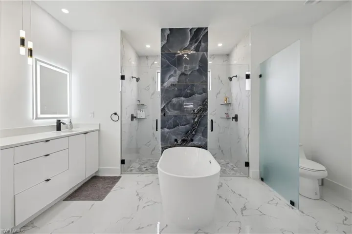 Full bathroom featuring vanity, toilet, tile patterned floors, and separate shower and tub