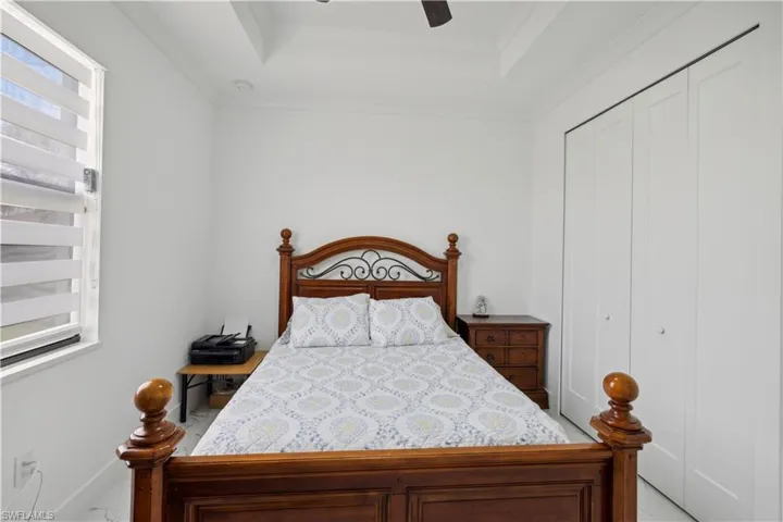 Bedroom featuring ornamental molding, a closet, ceiling fan, and a raised ceiling