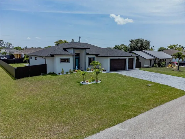 View of front of house featuring a garage and a front lawn