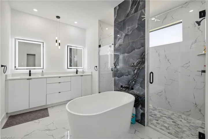 Bathroom with dual vanity, tile patterned floors, and plus walk in shower