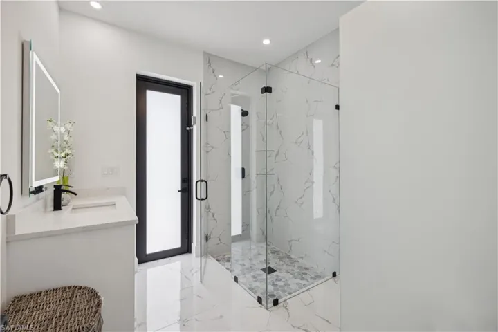 Bathroom with vanity, walk in shower, and tile patterned flooring