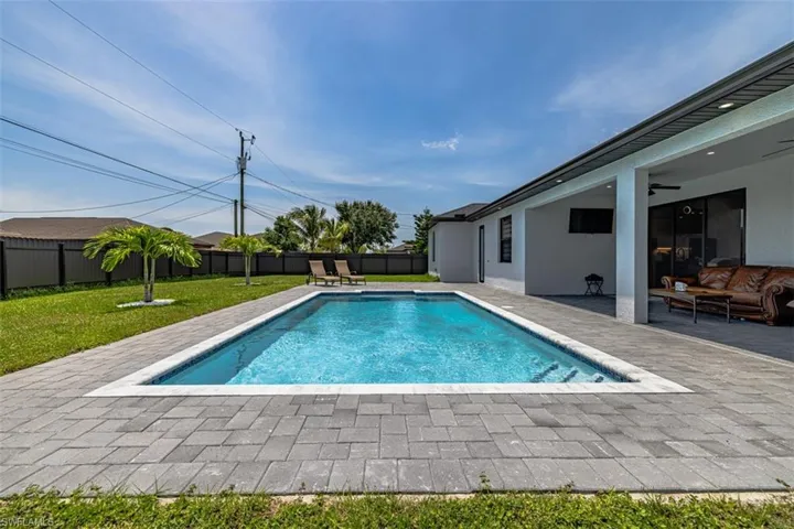 View of swimming pool featuring a yard, a patio area, and ceiling fan