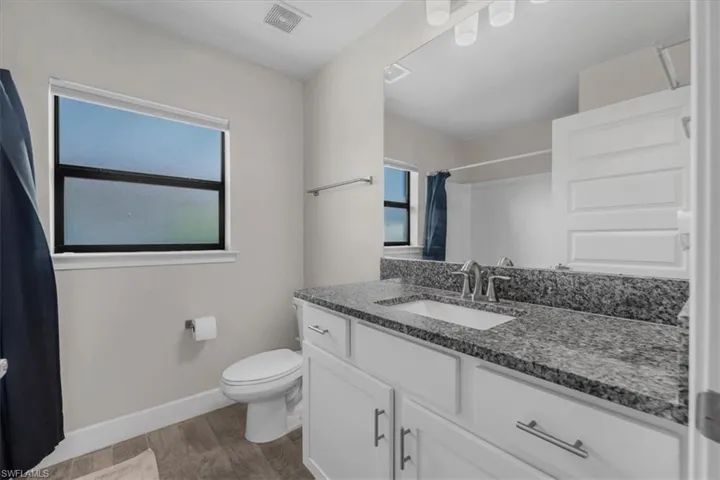 Bathroom featuring a vanity with granite countertop, undermount sink, and chrome faucet