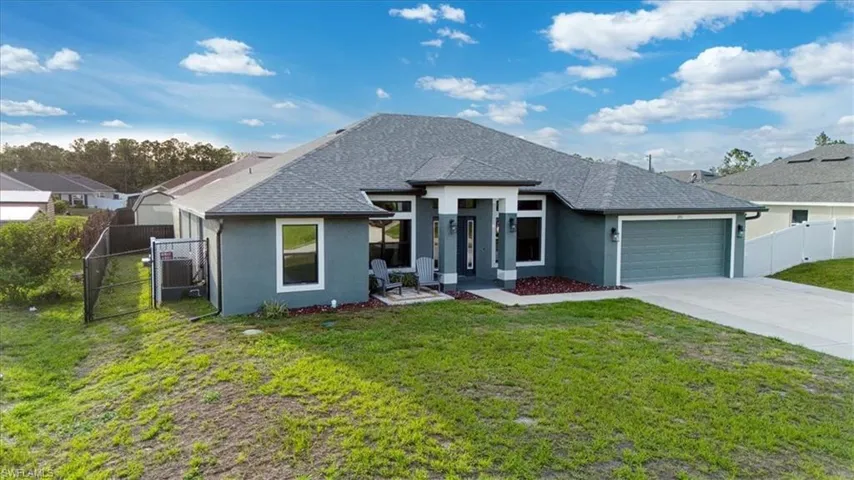 Contemporary single-story residence featuring a gray exterior, a two-car garage, and a concrete driveway