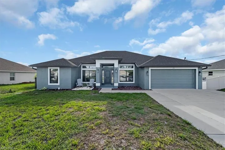 Contemporary stucco exterior with a dark gray roof, two-car garage, concrete driveway, and front entryway with architectural details