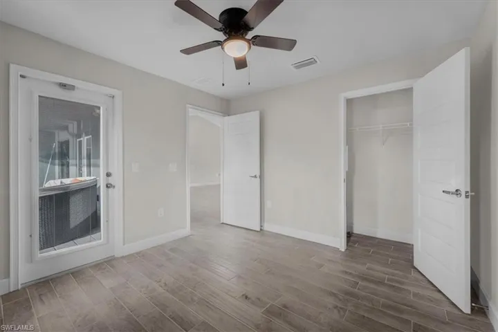Room with wood-finish tile flooring, a ceiling fan, and light gray wall paint