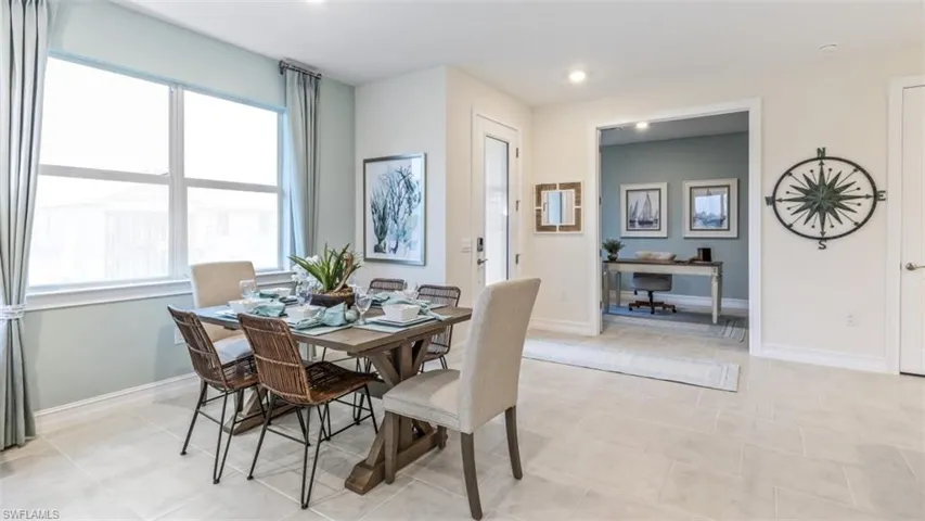 Bright dining area featuring large windows and tile flooring
