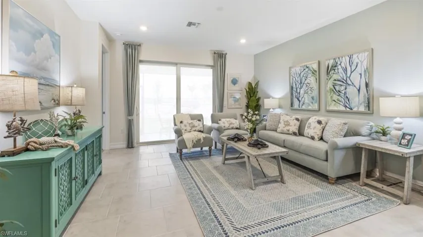 Recessed lighting, light-toned tile flooring, and a large sliding glass door