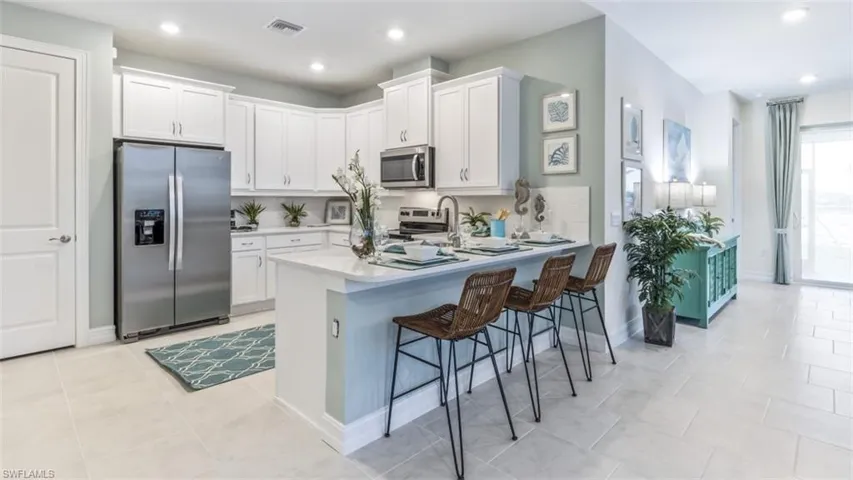 Gourmet kitchen with white cabinetry and stainless steel appliances