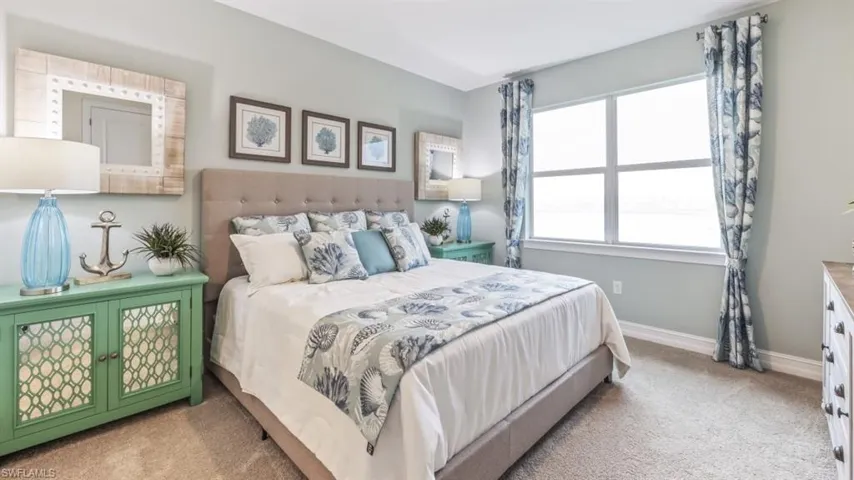 Carpeted flooring, a large window, and light-colored walls