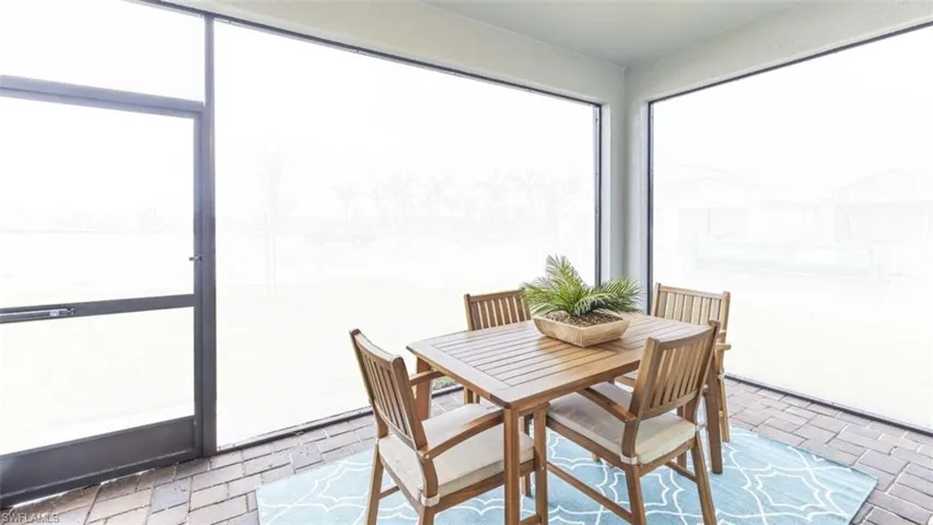 Screened outdoor living space featuring paver flooring and an exterior screen door