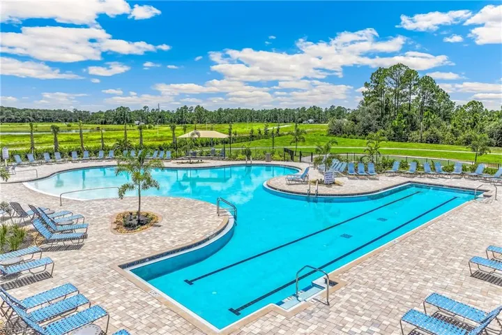 Expansive outdoor pool area featuring a multi-level swimming pool, separate lap lanes, and surrounding paver decking