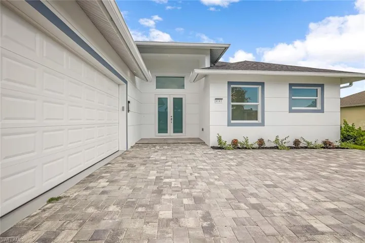 View of exterior entry with a garage and french doors