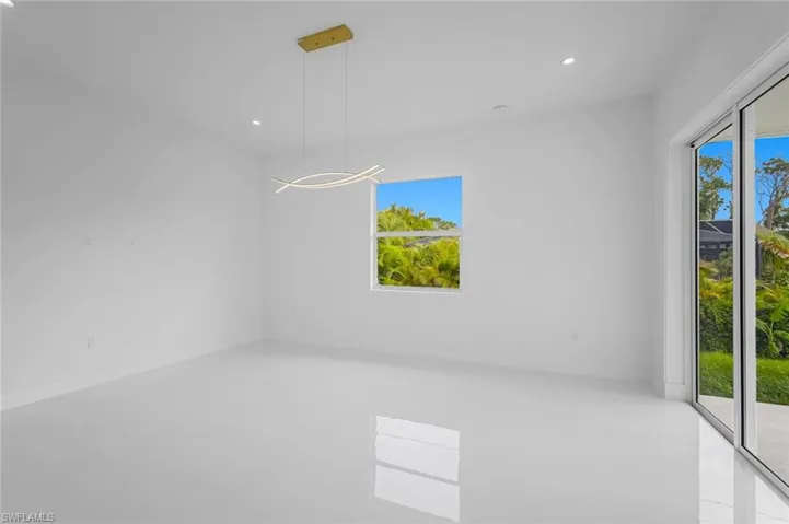 Unfurnished room with a wealth of natural light and a chandelier