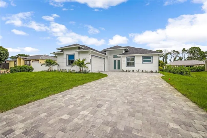 View of front of property featuring a front yard and a garage