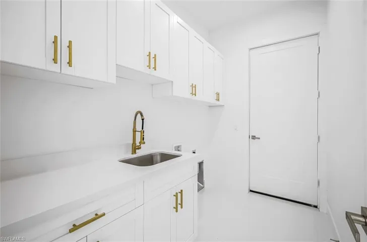 Kitchen featuring white cabinets and sink