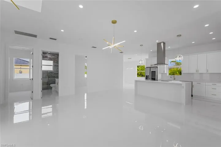 Unfurnished living room featuring a chandelier