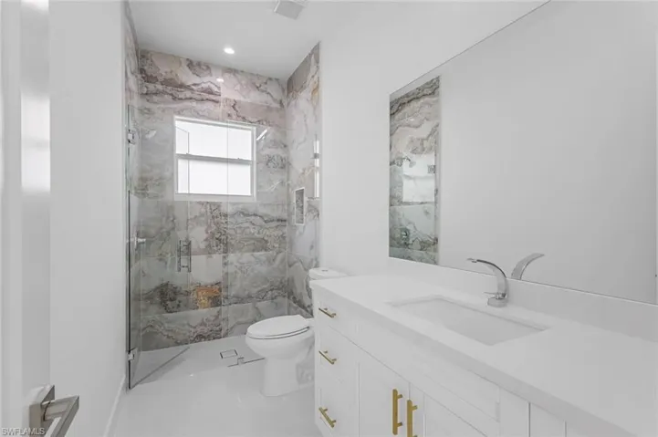 Bathroom with an enclosed shower, vanity, and toilet