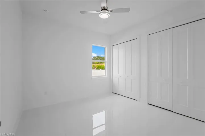 Unfurnished bedroom featuring ceiling fan and two closets