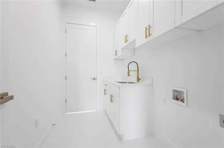 Washroom featuring washer hookup, cabinets, electric dryer hookup, and sink