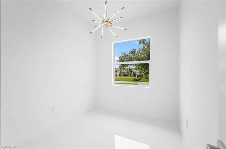 Unfurnished room featuring an inviting chandelier