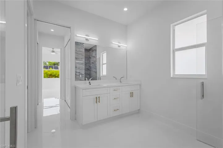 Bathroom featuring ceiling fan, a shower, and vanity