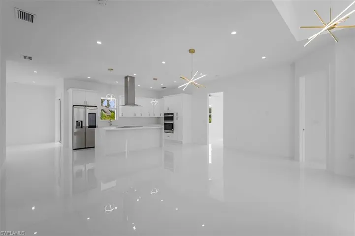 Unfurnished living room with a chandelier and a healthy amount of sunlight