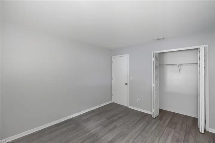 Unfurnished bedroom featuring wood finished floors and a closet