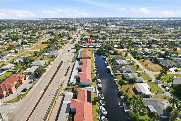 Aerial view of property and surrounding area with a nearby body of water and nearby suburban area
