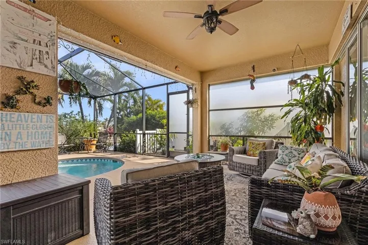 Sunroom featuring ceiling fan and a swimming pool with hot tub