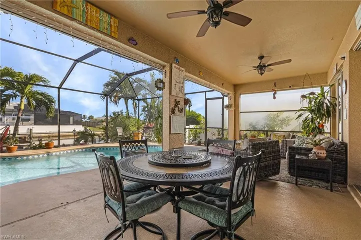 View of patio featuring glass enclosure, ceiling fan, and outdoor lounge area